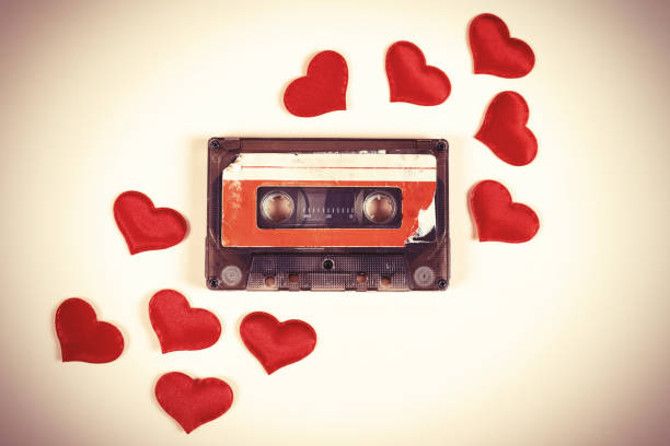 Old Audio Cassette Toned Photo of Old Audio Cassette with a Red Hearts on the Paper Background closeup mix tape heart stock pictures, royalty-free photos & images