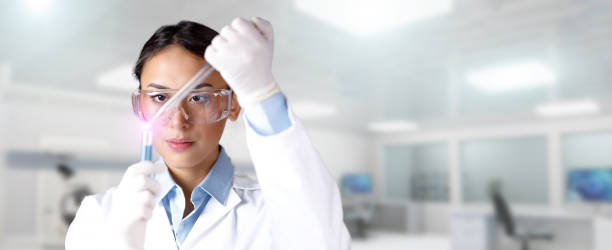 Female technician conducting an experiment in medical or chemistry laboratory stock photo
