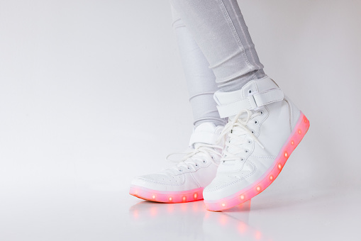 Person wearing white LED shoes with colorful soles