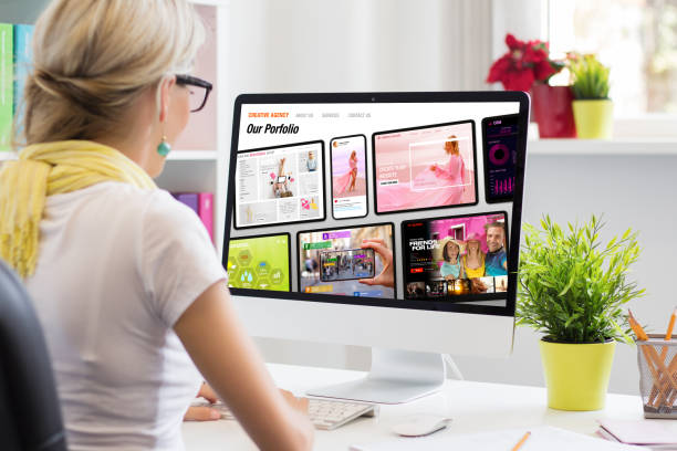 istock Woman working in office and viewing sample creative agency's website on computer screen 1354839101
