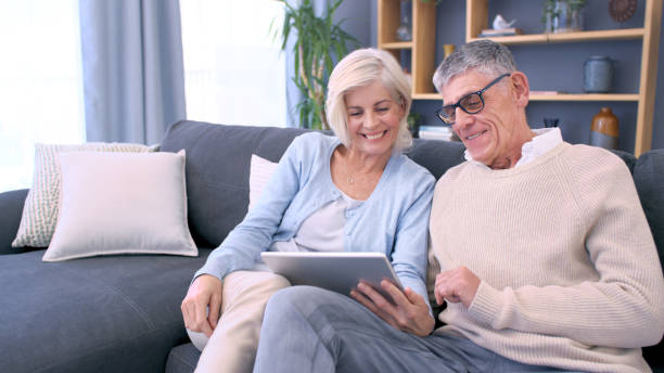 istock Shot of an older couple using a digital tablet on the sofa at home 1354840406