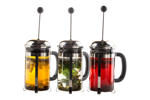 set of autumn homemade teas with citrus, mint and berries in french presses Hot fruit drinks collection with fragrant herbs and chopped fruits side view