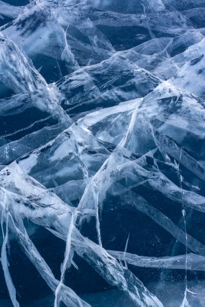 istock Natural ice with cracks. Blue thick ice with white cracks. Vertical. 1354841346
