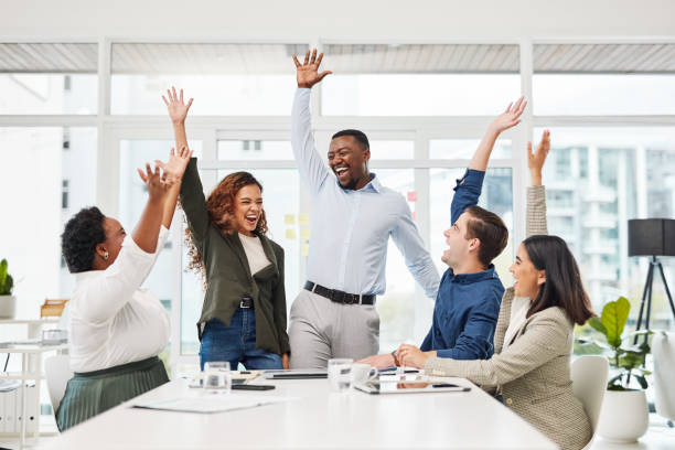 Shot of a group of businesspeople cheering during a meeting in an office stock photo