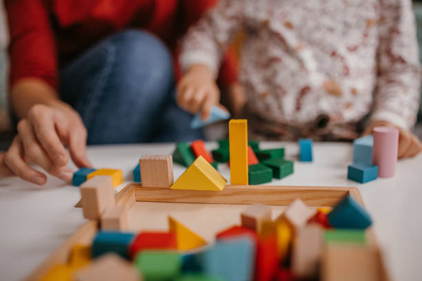 istock Mother and daughter playing with toy blocks 1354842254