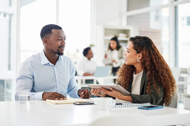 istock Shot of two businesspeople having a discussion while using a digital tablet together in an office 1354842285