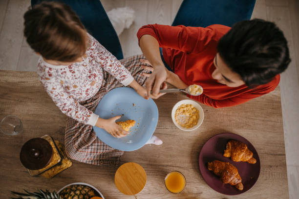 istock Mother and daughter eating together 1354842488