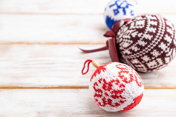 istock Christmas or New Year composition. Decorations, knitted balls, on a white wooden background. Side view, copy space, selective focus. 1354842921