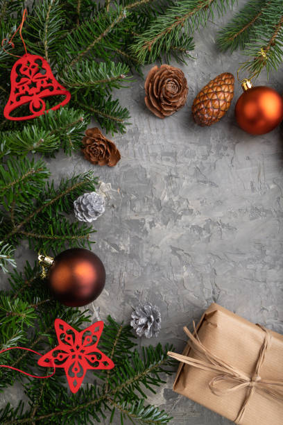 istock Christmas or New Year composition. Decorations, cones, cinnamon, fir and spruce branches, cup of coffee, wool scarf on a gray concrete background. Top view, copy space, flat lay. 1354843567
