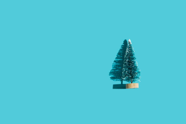 istock Toy plastic green Christmas tree on minimal blue background with hard shadow. Christmas and New Year background for congratulations on the coming holidays. Flat lay. Top view. Place for text. 1354848515