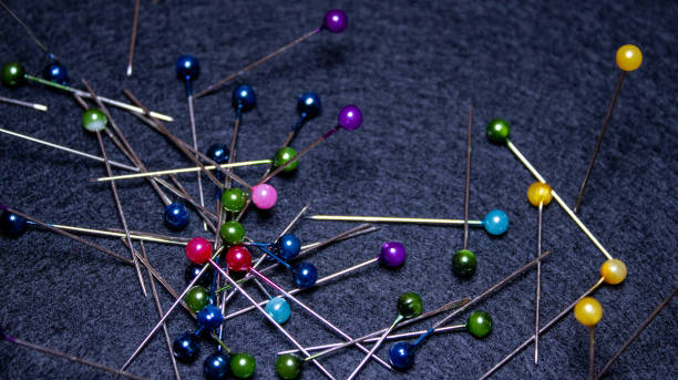 istock Colored pins on black cloth background, close focus 1354850020