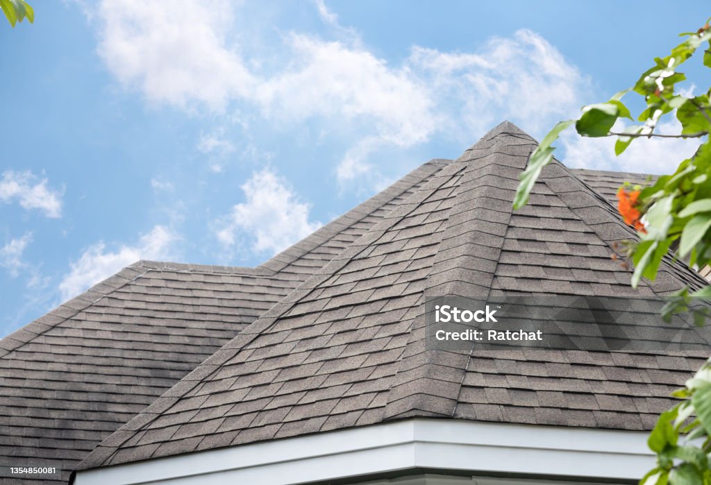 edge of Roof shingles on top of the house, dark asphalt tiles on the roof background. Rooftop Stock Photo
