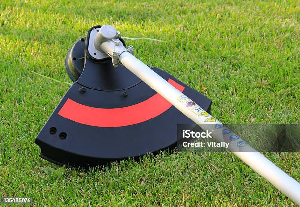 Weed Trimmer In Red And Black On The Grass Stock Photo - Download Image Now - Cutting, Hedge Clippers, Machinery