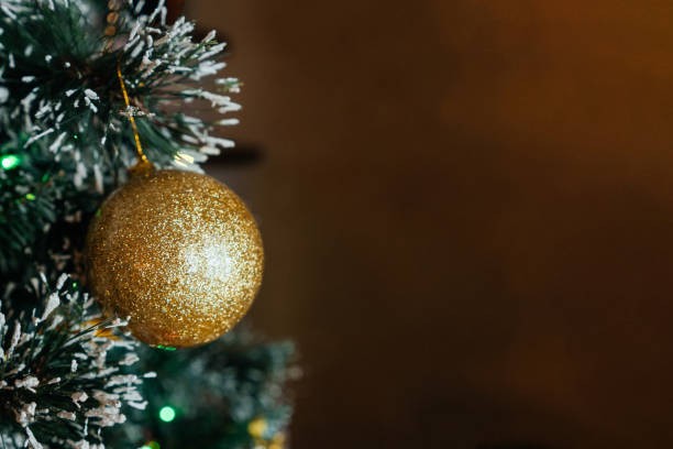 istock Christmas tree with golden ball, brown background. 1354850998