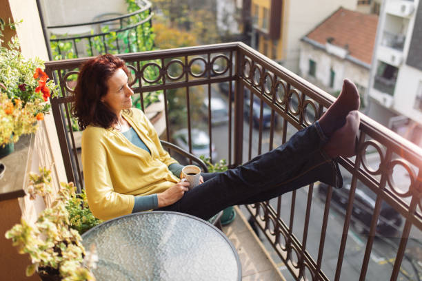 istock Mature woman relaxing on balcony at morning 1354851251