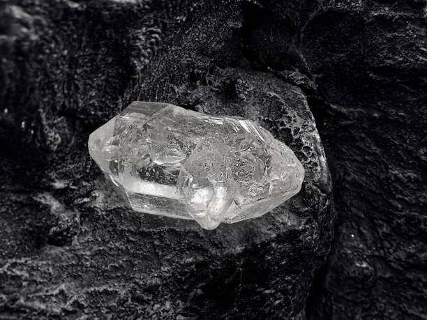 istock Natural diamond nestled on black coal background 1354852389