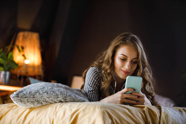 rotina noturna para uma adolescente - one teenage girl only on the phone bed lying on front - fotografias e filmes do acervo