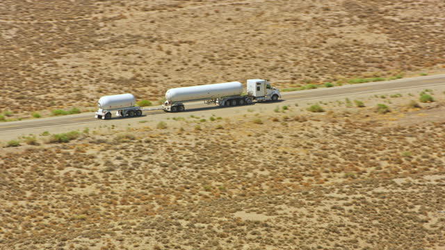 AERIAL A tank truck driving on a desert freeway in Nevada, USA