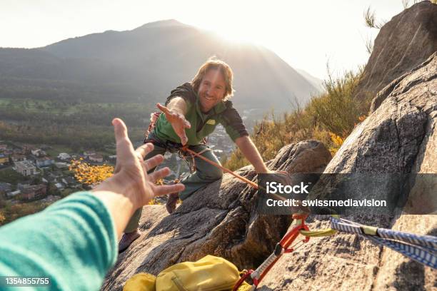 Male Rock Climber Reaches His Hand Out To Ask For Assistance Stock Photo - Download Image Now
