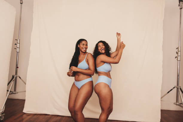 istock Cheerful young women dancing while wearing blue underwear 1354856056