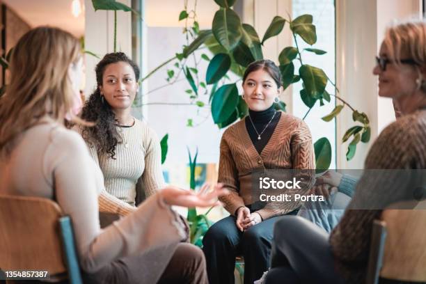 Woman Sharing Her Experiences During A Group Therapy Session Stock Photo - Download Image Now