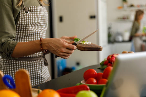 istock Woman about to put a chopped spring onion in a dish 1354858771