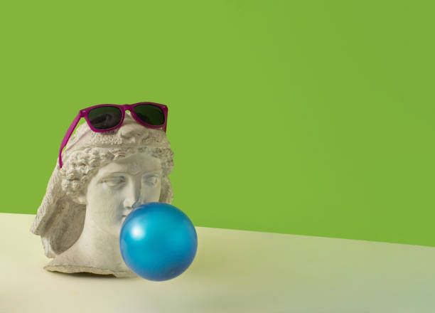 istock Pop art marble bust, with blue bubblegum and pink sunglasses. Minimal surreal composition on neon green and beige background. 1354858807