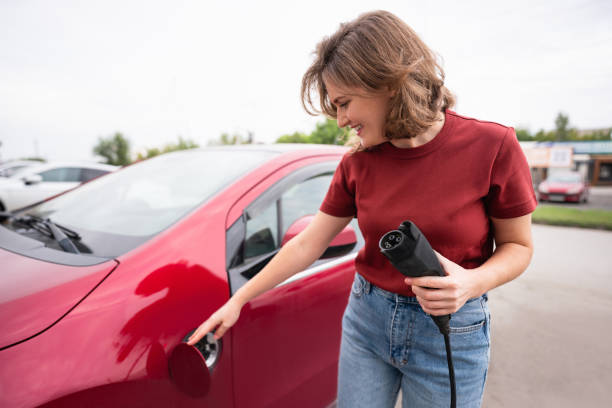 Woman holds a charging plug for an electric car