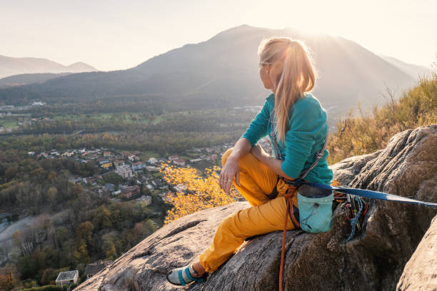 female mountain climber takes a break to enjoy the view - conquering adversity wilderness area aspirations achievement imagens e fotografias de stock