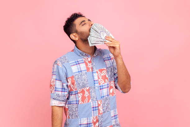 istock Portrait of handsome greedy arrogant man with beard smelling dollar banknotes with expression of pleasure, crazy about money, wealthy life. 1354858883