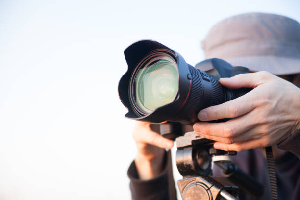 istock man taking pictures with DSRL 1354858963