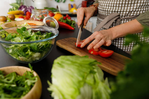 istock Woman cutting up tomatoes for a salad 1354859044
