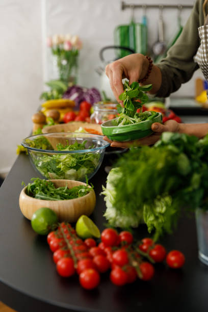 istock Enriching a nutritious salad with a handful of fresh greens 1354859057