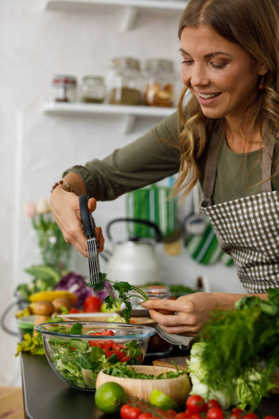istock Adding fresh parsley into a healthy salad she is preparing 1354859078