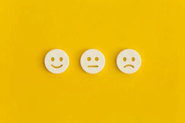 Photo of Emoticon smile on a yellow background. Customer feedback.