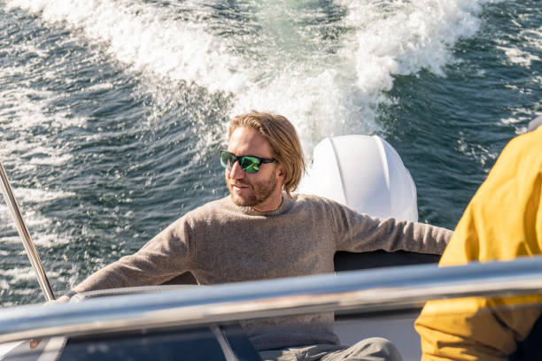istock Young man on boat on lake in Autumn 1354861070