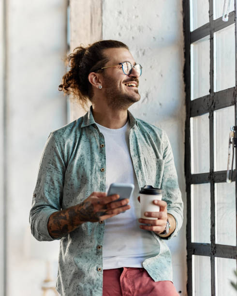 istock Happy freelancer using cell phone on coffee break by the window. 1354861094