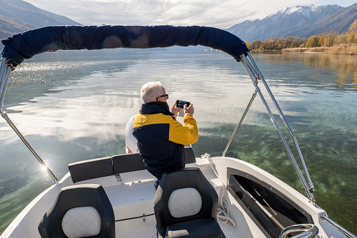 Male boat captain enjoying the lake and the mountains in Autumn.
Early retirement concept
