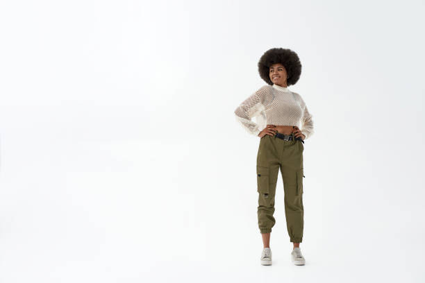 istock Young smiling black woman with hands on hips 1354861296