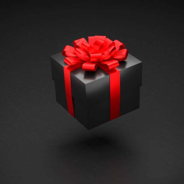 istock A black gift box with red ribbon and bow hovering over a black background. 1354861918
