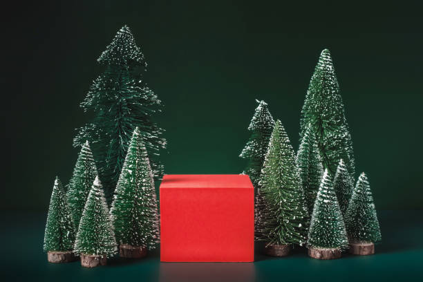 istock christmas tree group and red vivid product display block on green background. 1354862031