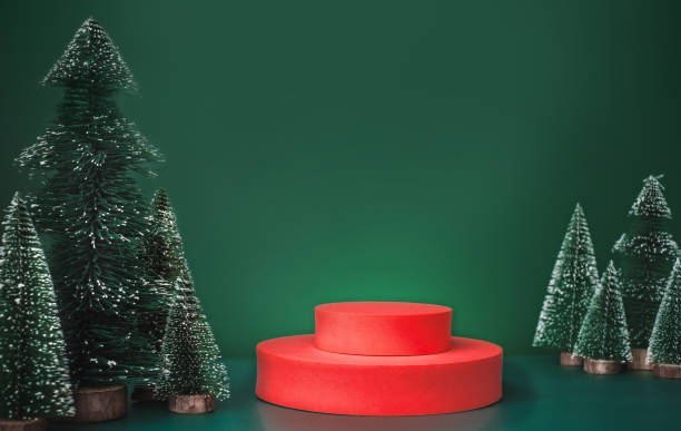 istock christmas tree group and red vivid product display block on green background. 1354862193