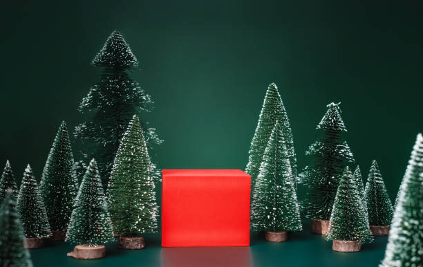istock christmas tree group and red vivid product display block on green background. 1354862215