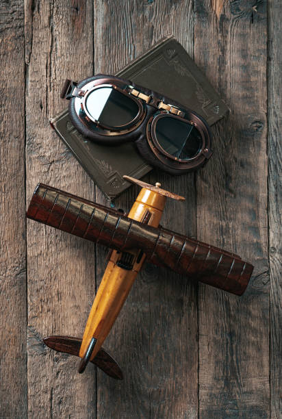 istock Aviation concept with toy airplane, aviator glasses and flight book. Vertical composition. 1354862699
