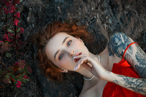 Beautiful red-haired woman in the forest, unity with nature, romantic mysterious portrait of a girl, twilight nature