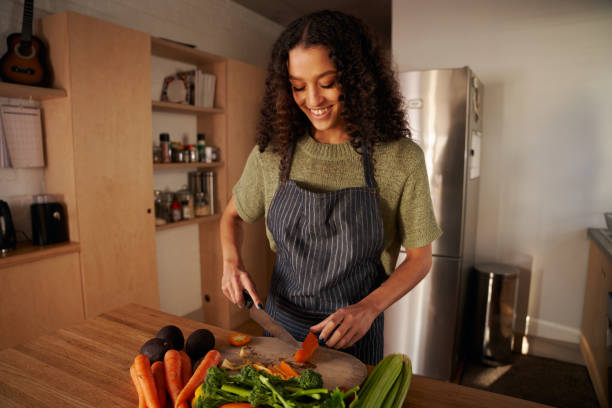 istock Multi-cultural young female chopping vegetables in modern kitchen, preparing healthy meal at home 1354864982