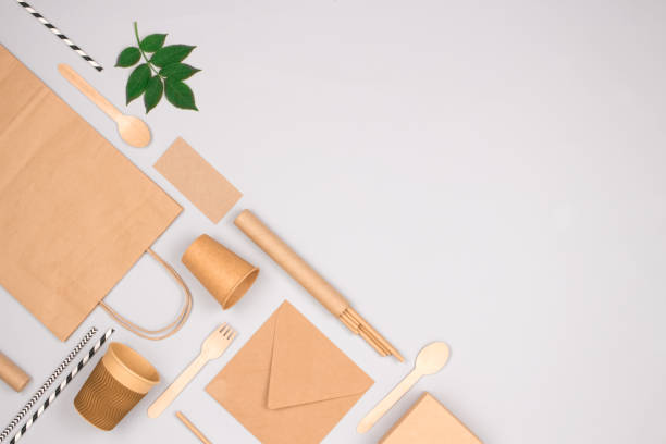 istock Set of different eco-friendly tableware and kraft paper food packaging on light gray background. Street food paper packaging - cups, plates, straws, containers and paper bags. Mockup, flat lay 1354865954