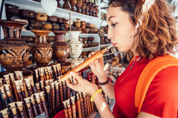 女性観光客が検査し、デュドゥクを吹こうとします - エレバンの手作りの市場で伝統的なアルメニアの楽器 - armenian ethnicity ストックフォトと画像