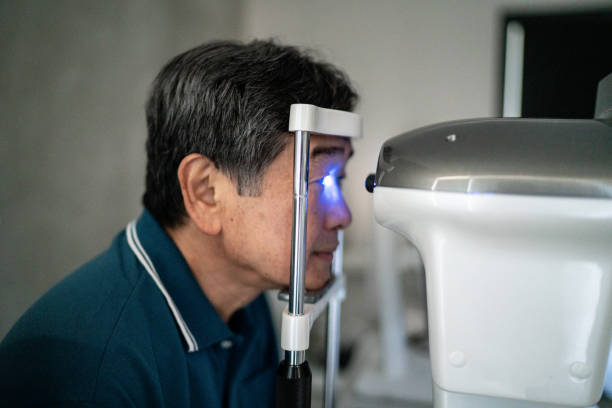 idoso fazendo um exame oftalmológico em uma clínica médica - patient senior adult optometrist eye exam - fotografias e filmes do acervo