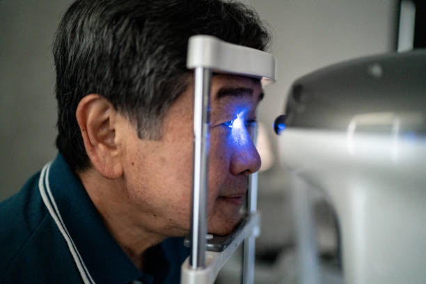 idoso fazendo um exame oftalmológico em uma clínica médica - patient senior adult optometrist eye exam - fotografias e filmes do acervo